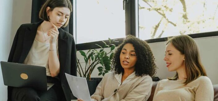 Women sitting on a sofa while talking business