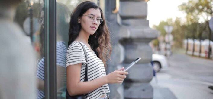 Young female using tablet on city street