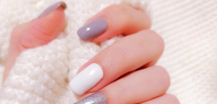 Person with lavender manicure holding wool
